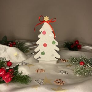 Λευκό πορσελάνινο χριστουγεννιάτικο δέντρο με ζωγραφισμένα στολίδια, κόκκινη κορδέλα και χρυσό αστέρι στην κορυφή.