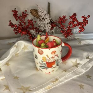 Χριστουγεννιάτικη κούπα με εσωτερικό διακοσμημένο με πράσινα και κόκκινα κεριά, κόκκινες λεπτομέρειες και χρυσόσκονη.