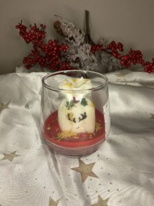 Χριστουγεννιάτικο κερί Winter Spark Gift Bag σε γυάλινο ποτήρι με λευκό σάκο δώρων, ζωγραφισμένο τάρανδο, κόκκινη βάση και χρυσόσκονη.