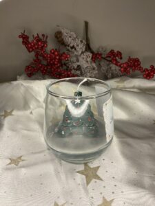 Χριστουγεννιάτικο κερί Winter Spark Christmas Tree σε γυάλινο ποτήρι με εσωτερικό κερί σε σχήμα πράσινου έλατου και λευκή βάση χιονιού.